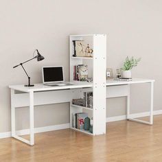 a white desk with a laptop computer on top of it next to a book shelf