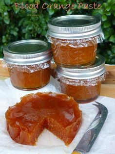 four jars filled with jam sitting on top of a table