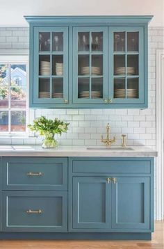 a kitchen with blue cabinets and white subway backsplash