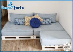 a couch made out of wooden pallets with pillows on it and a footstool