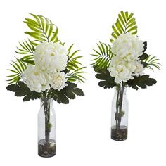 two vases filled with white flowers and greenery