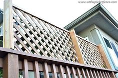 a close up of a wooden fence on a house's front porch with windows