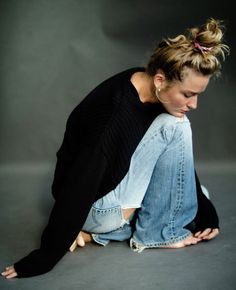 a woman sitting on the ground with her legs crossed