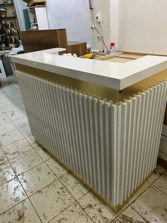 a white and gold striped counter top in a room with tile flooring on the ground