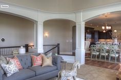 a living room filled with furniture next to a dining room table and chairs in front of a kitchen