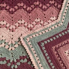 a crocheted blanket is laying on top of another afghan that has hearts in it