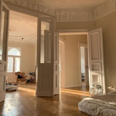 an empty bedroom with wooden floors and white walls, in the middle of a large room