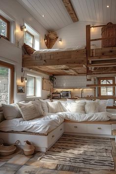 a living room filled with lots of furniture and pillows on top of a wooden floor