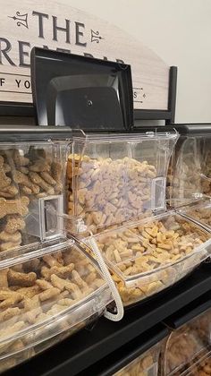 several plastic containers filled with food on top of a shelf in front of a sign