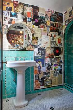 a bathroom with blue tiles and pictures on the wall, including an old record player