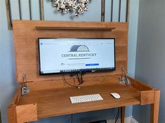 a computer monitor sitting on top of a wooden desk next to a keyboard and mouse