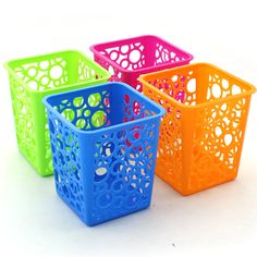 four different colored plastic baskets sitting next to each other on a white surface with holes in them