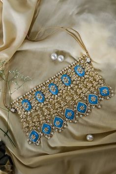 Gold toned choker necklace with Mughal cut work design, turquoise stones, pearl, kundan embellishment and drop tassel details. Paired with embellished dangler earrings and maangtikka. - Aza Fashions Blue Jewelry For Reception And Festivals, Blue Jewelry For Reception And Diwali, Blue Kundan Necklace For Reception Festivities, Blue Jewelry For Diwali Reception, Blue Kundan Necklaces For Reception, Blue Kundan Necklace For Reception, Blue Kundan Necklace For Reception And Festive Occasions, Blue Kundan Necklace For Festive Reception, Multicolor Kundan Tilla Choker Necklace