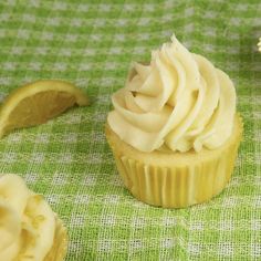 some cupcakes with frosting on a green table cloth