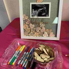 some crayons are sitting on a table next to an art project with hearts