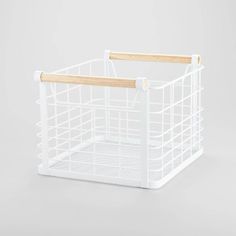 a white plastic basket with wooden handles