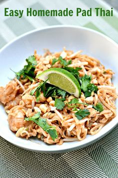 a white bowl filled with noodles and garnished with cilantro on top