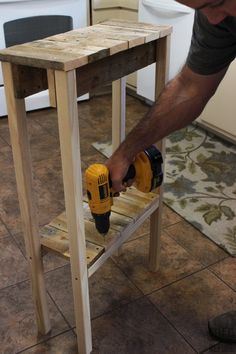 a man sanding up a wooden table with a driller and screwdriver