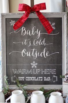 a chalkboard sign that says, baby it's cold outside and snowflakes on top