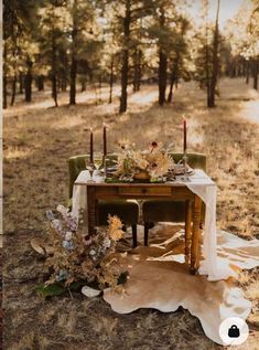 the table is set up for dinner in the woods