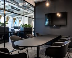 an empty conference room with chairs and a flat screen tv mounted to the wall above it