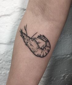 a black and white shrimp tattoo on the left arm, with an outline of it's claws