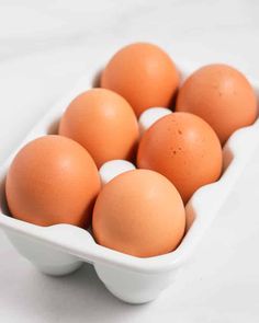 six brown eggs in a white bowl