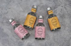 five bottles of ginzetto on a gray surface with silver caps and pink labels