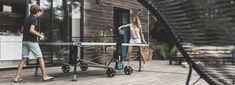 two people standing on a deck near a table