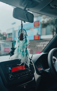 the dashboard of a car with a native american dream catcher hanging from it's center console