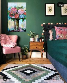 a bedroom with green walls and pink chairs