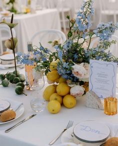 the table is set with lemons and blue flowers