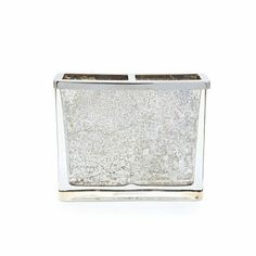 a silver square shaped object sitting on top of a white surface with dirt in it