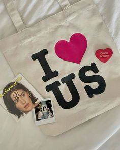 a white bag with the word i love us written on it and two photos attached to it