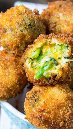 some fried food is in a blue bowl on a table with broccoli sprouts