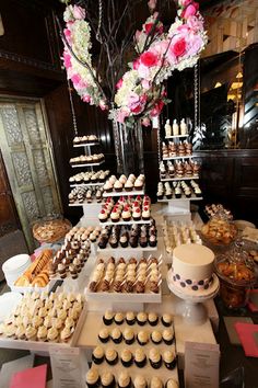 a table filled with lots of cupcakes and pastries