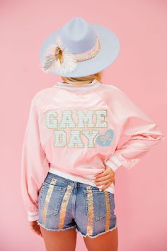 Gear up for the big game in our pink satin GAME DAY READY varsity jacket! With blue striped letters and a beaded bow heart patch, you'll stand out on the sidelines. Plus, the soft satin fabric will keep you comfortable and stylish all day long. Are you ready?! All orders are currently shipping within 14 business days. To receive item quicker, expedited shipping is available at checkout. Spring Varsity Jacket With Letter Embroidery, Pink Varsity Jacket For College, Sporty Pink Varsity Jacket For College, Pink Varsity Jacket With Letter Print For College, Pink College Varsity Jacket With Letter Print, Collegiate Varsity Jacket With Baseball Collar For Spring, Pink Sporty Varsity Jacket For Spring, Sporty Pink Varsity Jacket For Spring, Pink Letter Print Outerwear For Spring