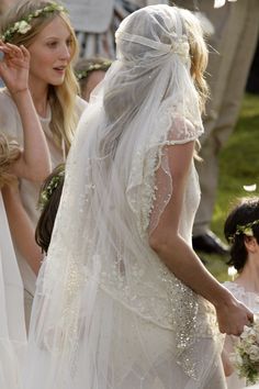 the bride is walking down the aisle with her veil draped over her head