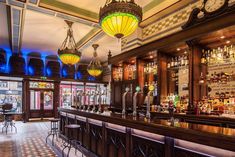 a bar with several lights hanging from the ceiling