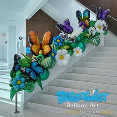 a bunch of colorful butterflies are on the stair rail at the bottom of a flight of stairs