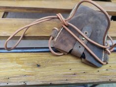 a brown leather bag sitting on top of a wooden bench