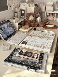 the desk is cluttered with books, papers and a teddy bear