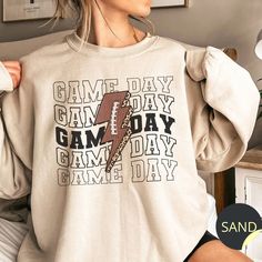 Game Day Sweatshirt, Game Day Vibes Crewneck, Womens Football Sweatshirt, Retro Game Day Pullover, Football Mom Sweater, Football Game Shirt These Gildan 18000 heavy blend crewneck sweatshirts are made from 50% polyester and 50% cotton. This combination helps designs come out looking fresh and beautiful. The collar is ribbed knit, so it retains its shape even after washing. There are no itchy side seams on these sweaters. The sweatshirts are unisex sizing. Please double check the measurements pr Cute Football Sweatshirts, Spring Game Outfit Football, Football Vinyl Shirts, Etsy Shirt Ideas, Game Day Shirt Ideas, College Football Shirts, Football Sweaters, Football Mom Shirts Ideas, Football Tshirt Designs