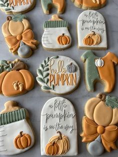 decorated cookies are arranged on a table with words and pumpkins in the background,