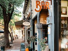 a store front with an orange and white sign on the door that says bar in it