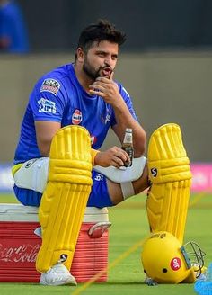 a man sitting on top of a field next to a ball