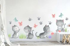 a cat wall decal in a child's room with butterflies and paw prints