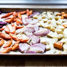 there are many different types of vegetables on the baking sheet, including carrots and onions