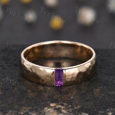 a gold ring with a purple stone in it