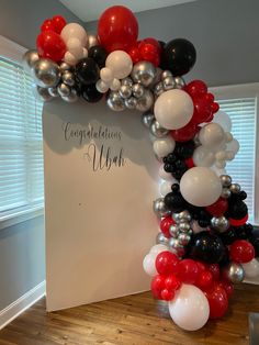 an arch made out of balloons with congratulations written on it